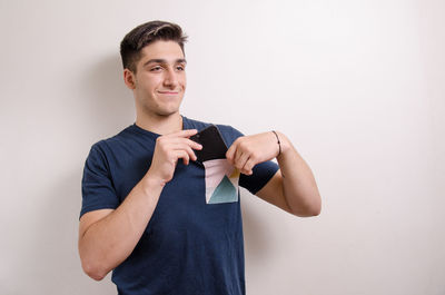 Portrait of young man standing against white background