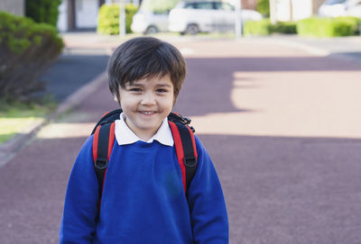 Portrait of happy child boy with backpack, school kid waiting for school bus,back to school concept