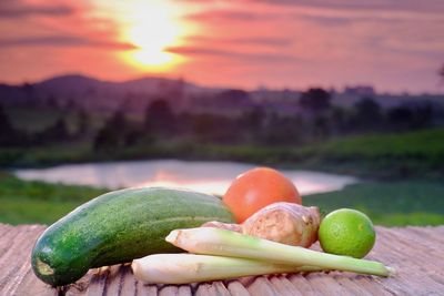 Close-up of fruits on table against sky during sunset