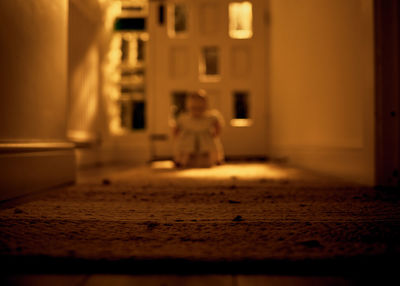 Rear view of woman sitting at entrance of building