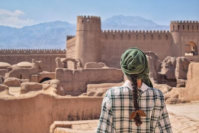 Rear view of man looking at historical building