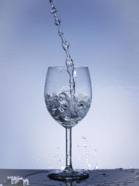 Close-up of wine glass against blue background