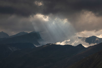 Scenic view of mountains against cloudy sky