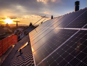 Solar panels against sky during sunset