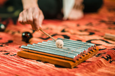 Cropped hand playing musical instrument on table