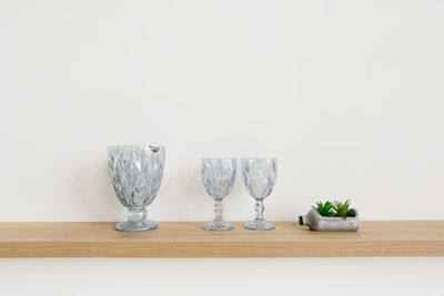 Stylish glass glasses in the decor of the dining room or living room on a wooden shelf