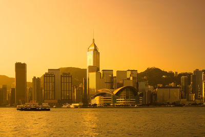 Victoria harbour, hong kong island, hong kong, china - skyline of skyscrapers in wan chai at dawn.