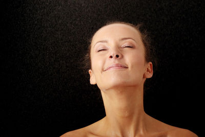 Portrait of a beautiful young woman over black background