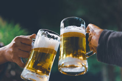 Midsection of woman holding beer glass