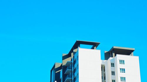 Low angle view of modern building against blue sky