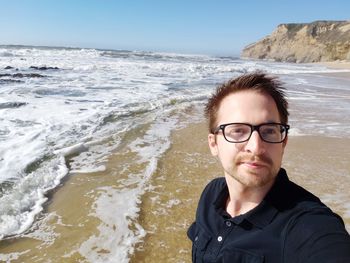 Portrait of man wearing sunglasses at beach