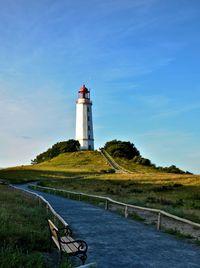 Lighthouse by sea against sky