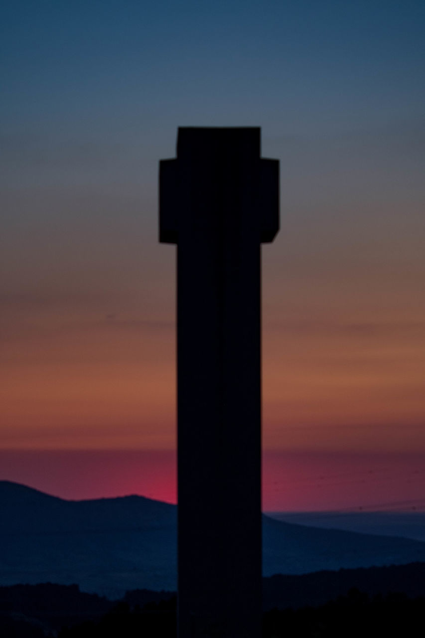 SILHOUETTE CROSS AGAINST ORANGE SKY