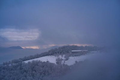 Snow covered landscape against sky