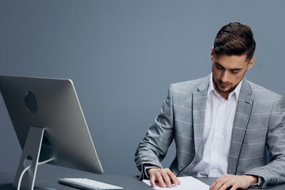 Young man using laptop at desk in office