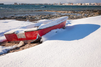 Boat moored on beach against sky