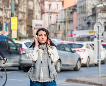 Young woman standing on street in city