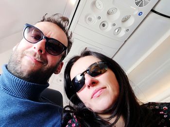 Portrait of couple wearing sunglasses in airplane