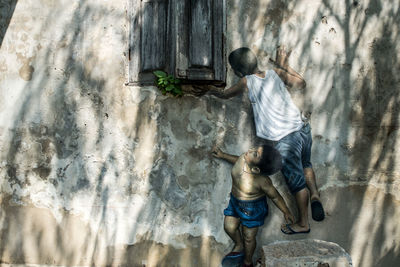 Rear view of boy standing against wall