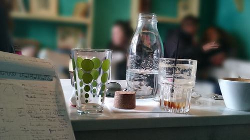 Drinking glasses and bottle on table at restaurant