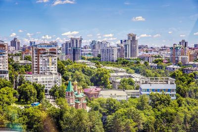 Trees and cityscape against sky