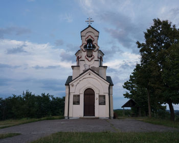 Low angle view of clock tower by building against sky