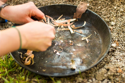 Close-up of hands kindling a fire with natural material