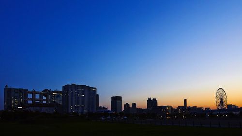 View of city lit up at sunset