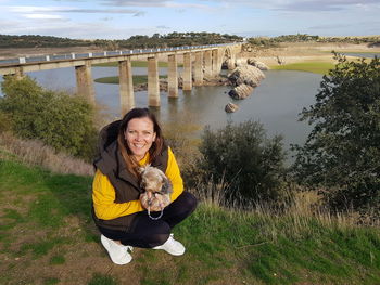 Portrait of smiling woman with dog in water