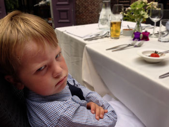 Close-up portrait of angry boy sitting at dining table