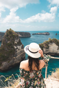 Rear view of woman looking at sea against sky