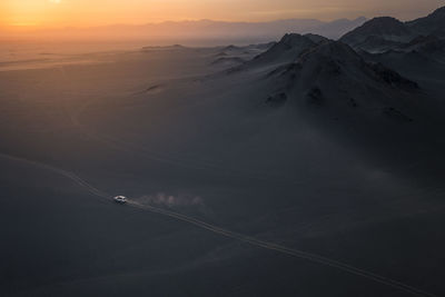 Aerial view of snowcapped mountain against sky during sunset