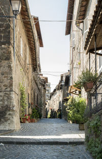 Alley amidst buildings in town against sky