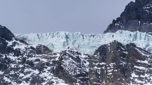 Scenic view of snowcapped mountains against clear sky