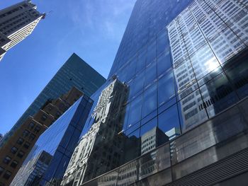 Low angle view of modern buildings against sky at manhattan in city
