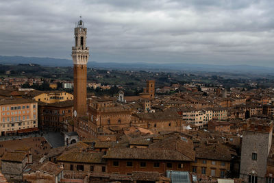 Buildings in city against cloudy sky