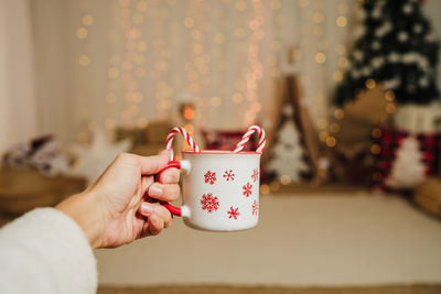 Midsection of woman holding coffee on table
