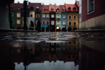 Reflection of buildings in puddle on street