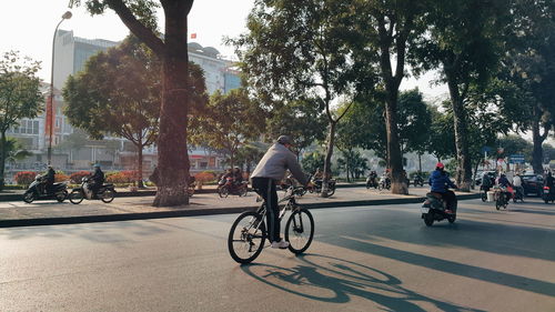 People riding bicycle on street in city