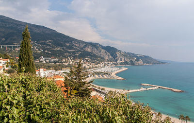 Aerial view of town by sea against sky