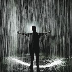 Silhouette man standing on road during rainy season