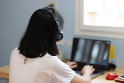 Young woman using computer to work from home during pandemic lockdown