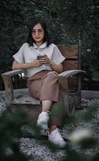 Portrait of young woman sitting on bench