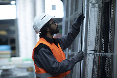 Young worker checking strips in hall