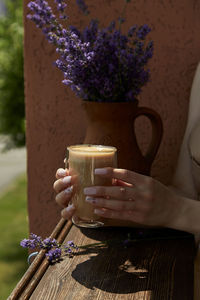 Midsection of woman holding drink on table