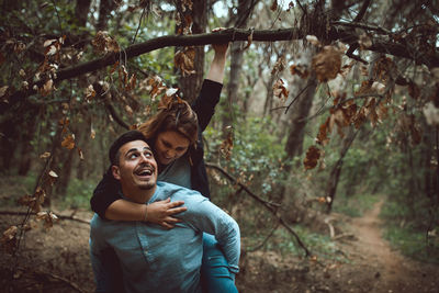 Portrait of smiling young woman in forest