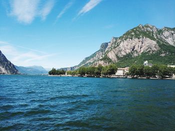 Scenic view of sea and mountains against blue sky