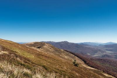 Scenic view of mountains against clear blue sky