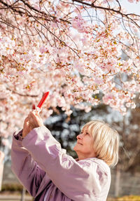 Young woman holding cherry blossom