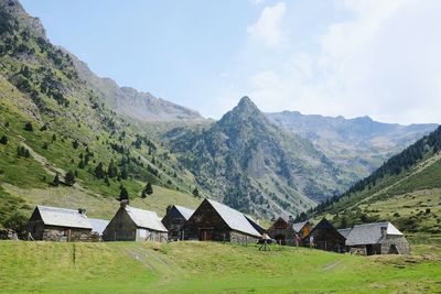 Houses on field against mountains